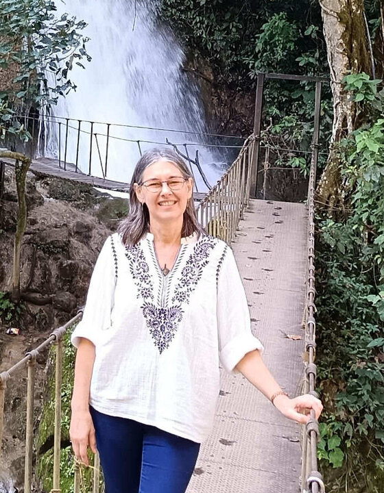 Sandrine Petit, naturopathe-iridologue, sur une passerelle devant une cascade